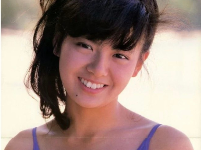 南野陽子若い頃の可愛い画像：鮮やかな青い水着に身を包んだ彼女が、明るい笑顔でこちらを見つめています
